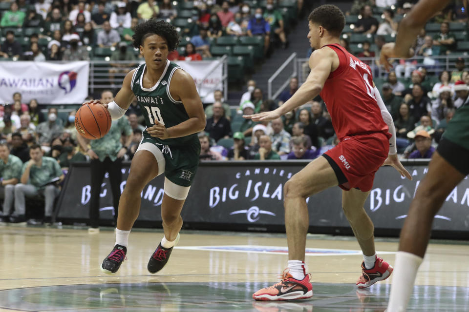 Hawaii guard Beon Riley (10) tries to get past SMU forward Samuell Williamson (11) during the first half of an NCAA college basketball game, Sunday, Dec. 25, 2022, in Honolulu. (AP Photo/Marco Garcia)