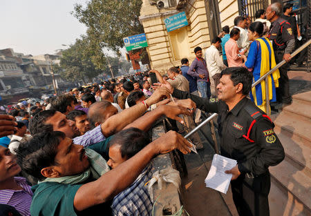 A security guard hands out request slips for the exchange of old high denomination bank notes at a branch of the State Bank of india in Old Delhi, November 10, 2016. REUTERS/Cathal McNaughton TPX IMAGES OF THE DAY