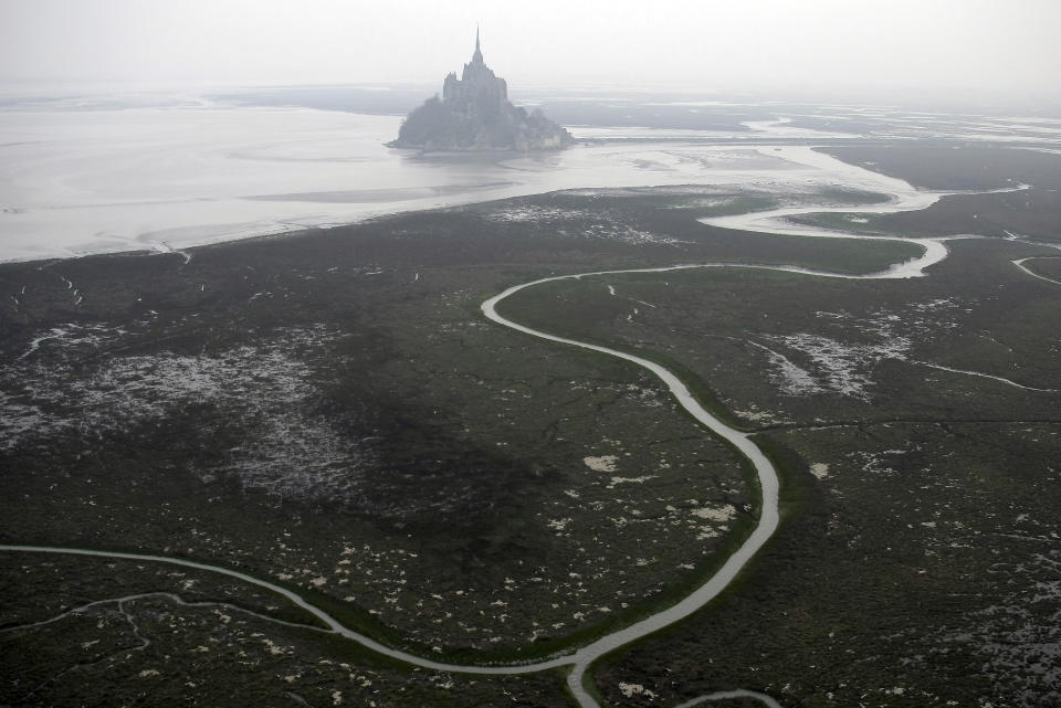 FILE - An aerial view of Mont Saint Michel, Normandy, France, March 20, 2011. The Olympic torch finally enters France when it reaches the southern seaport of Marseille on Wednesday May 8, 2024, on an armada from Greece. After leaving Marseille a vast relay route will be undertaken before the torch's odyssey ends on July 27 in Paris. A notable stop includes the stunning island of Mont-Saint-Michel. (AP Photo/David Vincent, File)