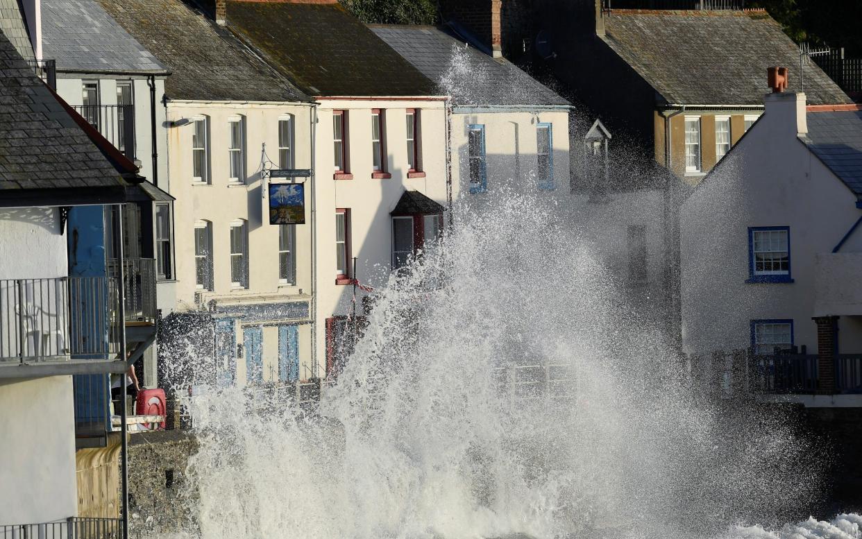 Waves hit the sea wall in Kingsand, Cornwall, in August - TOBY MELVILLE /REUTERS