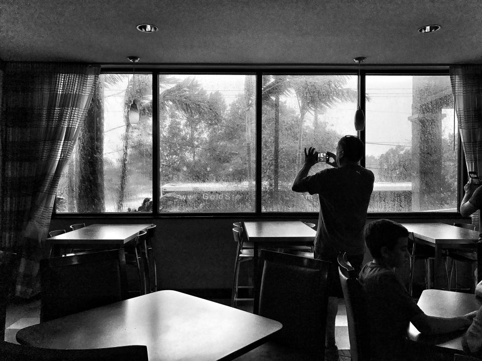 <p>A man photographs the scene outside the hotel as wind gusts nearing 100 mph from Hurricane Irma hit Sunday in Miami, Fla. (Photo: Holly Bailey/Yahoo News) </p>