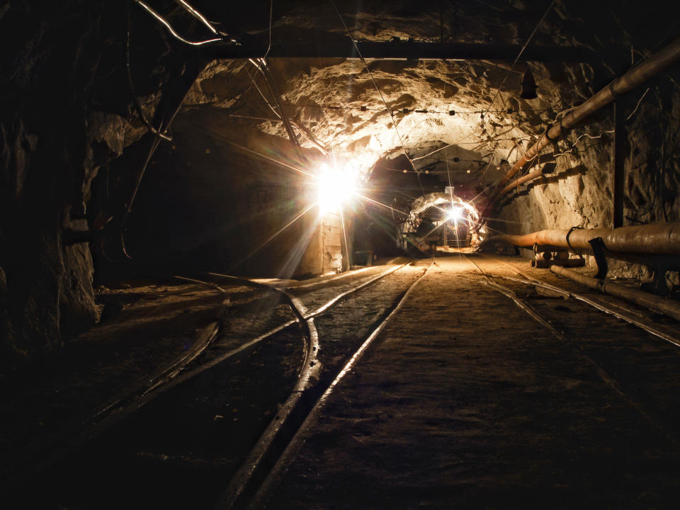 A tunnel in a coal mine with lights in the distance