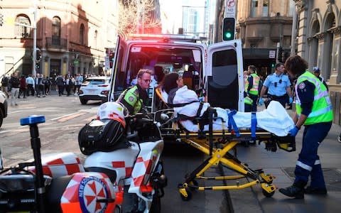 A woman is taken to hospital from Hotel CBD in Sydney - Credit: AAP Image