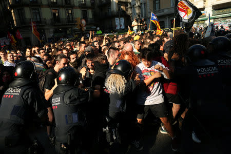 Separatist protesters scuffle with Mossos d'Esquadra police officers as they protest against a demonstration in support of the Spanish police units who took part in the operation to prevent an independence referendum in Catalonia on October 1, 2017, in Barcelona, Spain, September 29, 2018. REUTERS/Jon Nazca