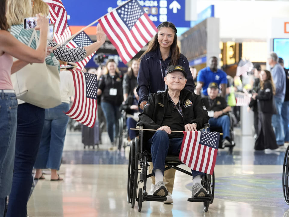 World War II veteran Martin Sylvester is helped along at Dallas Fort Worth International Airport in Dallas Friday, May 31, 2024. A group of World War II veterans are being flown from Texas to France where they will take part in ceremonies marking the 80th anniversary of D-Day. (AP Photo/LM Otero)