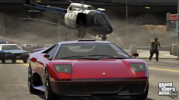 A screen shot from Grand Theft Auto 5 showing a red sports car being chased by police cars and a helicopter.