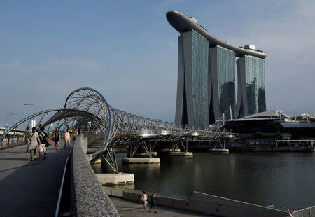 FILE PHOTO: People walk past the Marina Bay Sands hotel in Singapore April 10, 2017. REUTERS/Edgar Su/File Photo