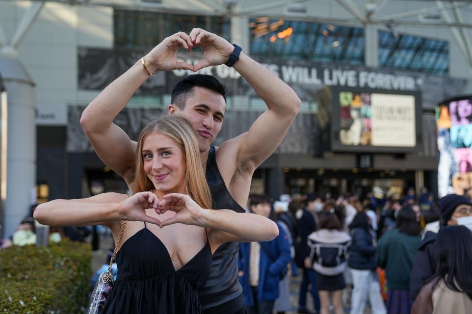 Mae Hurtig and Chris Olsen show their hearts in Tokyo before night one of the Eras Tour.