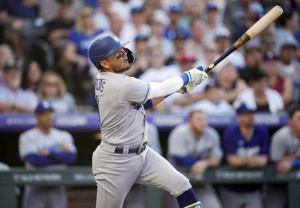 Los Angeles Dodgers' Miguel Rojas follows the flight of his sacrifice fly to drive in a run against Colorado Rockies starting pitcher Connor Seabold in the second inning of a baseball game Tuesday, June 27, 2023, in Denver. (AP Photo/David Zalubowski)