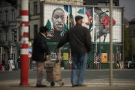 Two people stand in front of a mural of George Floyd, painted by Belgian artist Julien Crevaels, also known as NovaDead, in the center of Brussels, Wednesday, April 21, 2021. The guilty verdict in the trial over George Floyd's death was not just celebrated in America. It signaled hope for those seeking racial justice and fighting police brutality on the other side of the Atlantic, where Black Lives Matter has also become a rallying cry.(AP Photo/Francisco Seco)