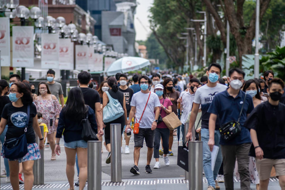 People wearing face masks as a preventive measure against the spread of Covid-19 walk along Orchard Road, the famous shopping district. 