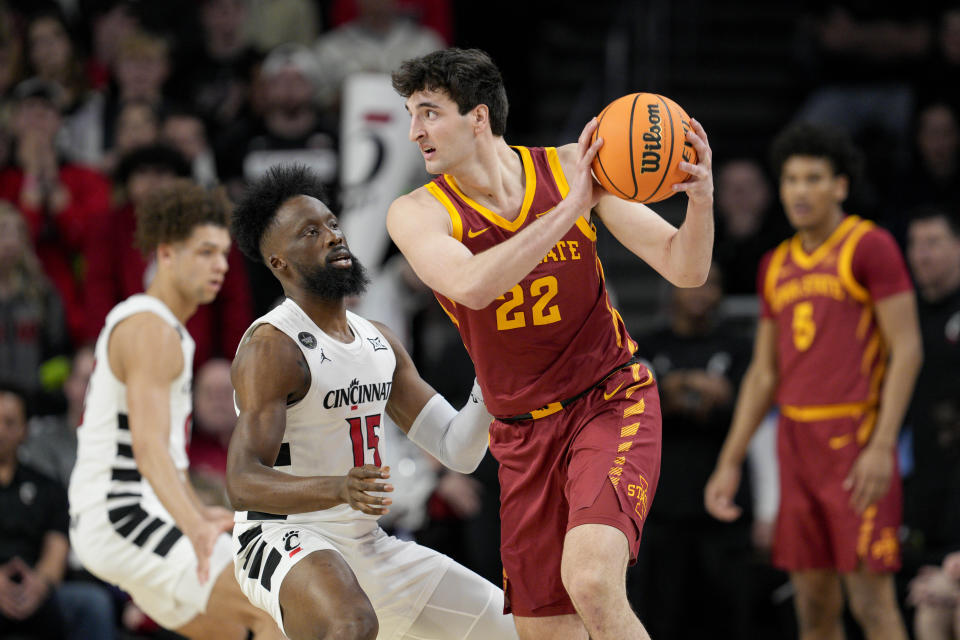 Iowa State forward Milan Momcilovic (22) controls the ball against Cincinnati's John Newman III during the first half of an NCAA college basketball game, Tuesday, Feb. 13, 2024, in Cincinnati. (AP Photo/Jeff Dean)