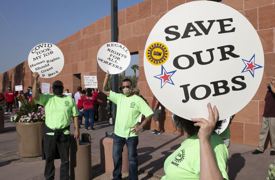 FILE - In this Aug. 18, 2020 file photo Alex Santana, left, Jim Soldate and Donna Blair, right, rally outside of the Clark County Commission Building in Las Vegas. The two largest Las Vegas casino companies have agreed with unions to let tens of thousands of employees keep family health benefits until next March 1. The powerful culinary and bartenders unions announced Monday, Aug. 31, 2020, the pact affects about 36,000 union workers at 22 Las Vegas Strip properties. (Bizuayehu Tesfaye/Las Vegas Review-Journal via AP, File)