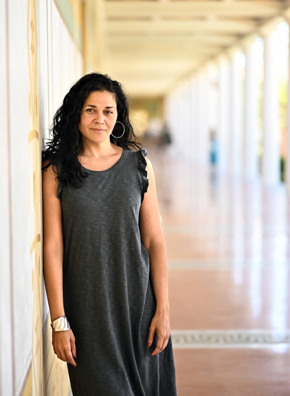 An actress poses against a column.