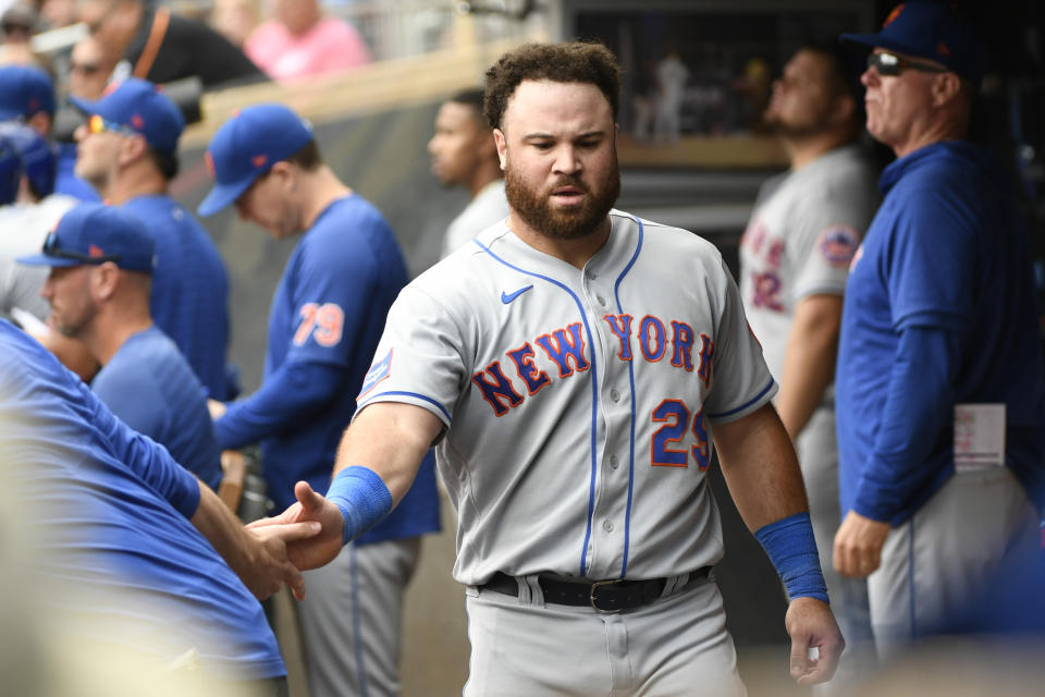 New York Mets' DJ Stewart slaps hands in the dugout after hitting a two-run double against the Minnesota Twins during the ninth inning of a baseball game Sunday, Sept. 10, 2023, in Minneapolis. (AP Photo/Craig Lassig)