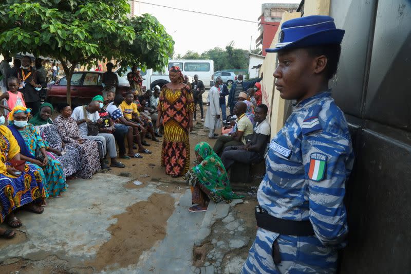 People wait for the opening of a polling office during the presidential election in Abidjan