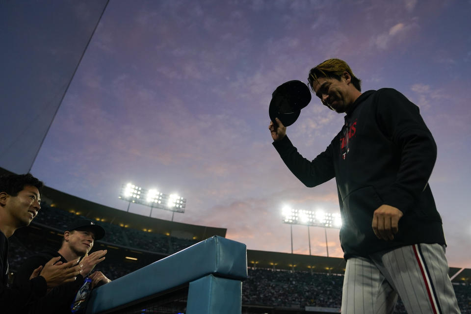 Minnesota Twins' Kenta Maeda, right, waves to the crowd as he is acknowledged during the second inning of a baseball game against the Los Angeles Dodgers in Los Angeles, Monday, May 15, 2023. (AP Photo/Ashley Landis)