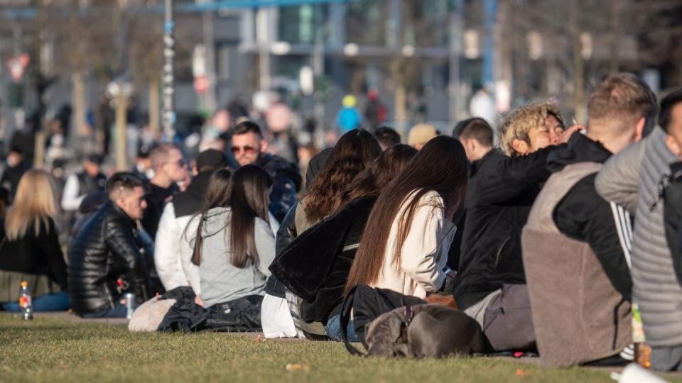 Meist jüngere Menschen sitzen am vergangenen Wochenende im Frankfurter Hafenpark. Das frühlingshafte Wetter hat auch an diesem Wochenende erneut viele Menschen ins Freie gelockt.