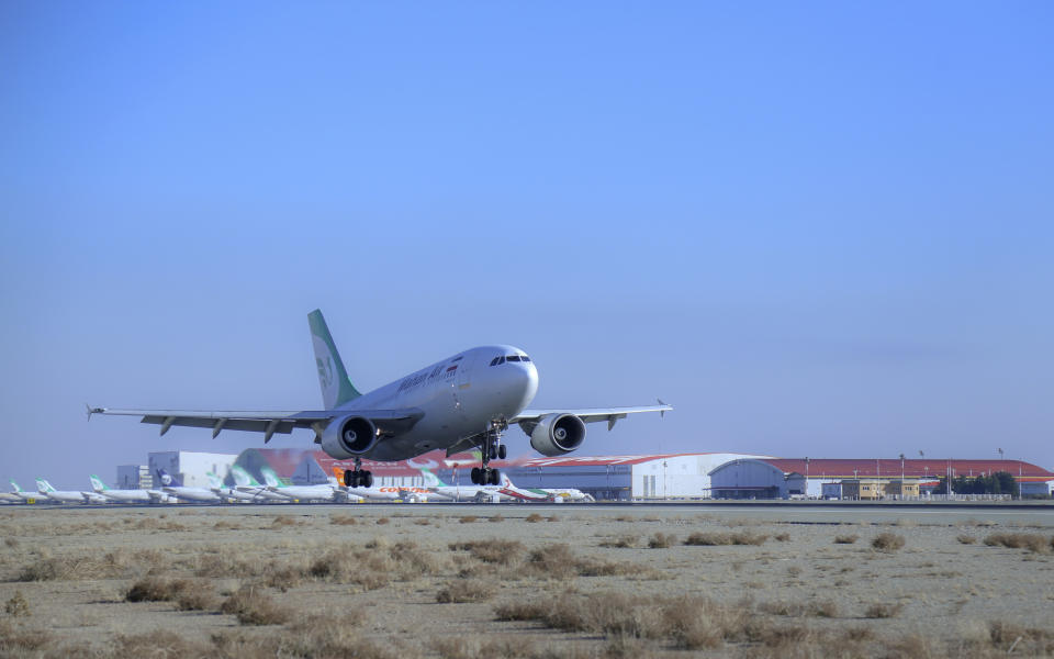 In this photo released by Imam Khomeini Airport City, an Iranian Mahan Air plane carrying Russian-made Sputnik V coronavirus vaccines lands at the Tehran's Imam Khomeini International Airport, Thursday, Feb. 4, 2021. Iran on Thursday received its first batch of foreign-made coronavirus vaccines as the country struggles to stem the worst outbreak of the pandemic in the Middle East. (Saeed Kaari/IKAC via AP)