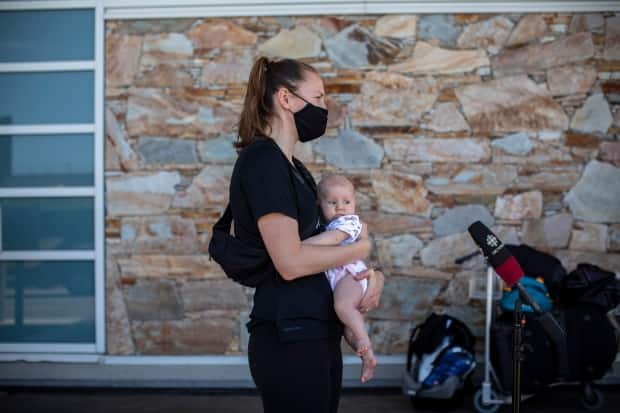 Team Canada basketball player Kim Gaucher is pictured with her daughter Sophie outside of Vancouver International Airport earlier in June. On Wednesday, the Tokyo Organizing Committee announced Olympians would be allowed to bring newborns like Sophie to Japan. (Ben Nelms/CBC - image credit)