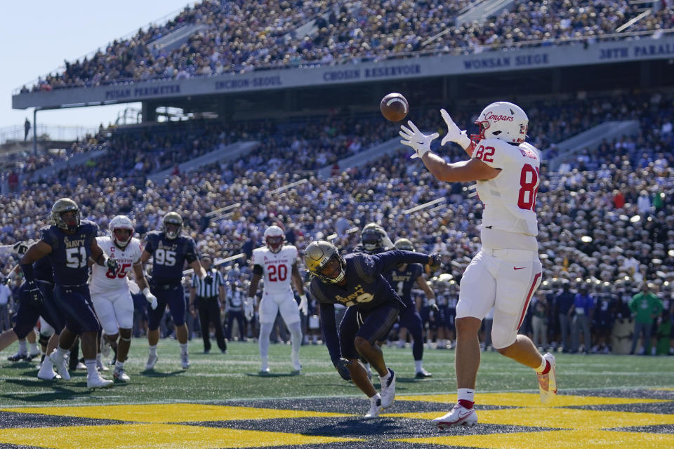 Houston tight end Matt Byrnes makes a touchdown catch in front of Navy safety Rayuan Lane III (18) during the first half of an NCAA college football game, Saturday, Oct. 22, 2022, in Annapolis, Md. (AP Photo/Julio Cortez)