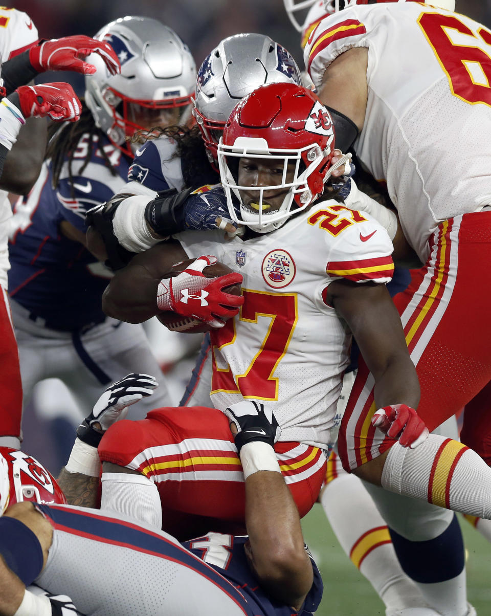 Kansas City Chiefs running back Kareem Hunt (27) is tackled by New England Patriots defenders during the first half of an NFL football game, Sunday, Oct. 14, 2018, in Foxborough, Mass. (AP Photo/Michael Dwyer)
