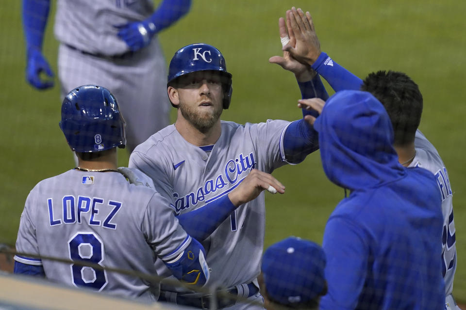 Kansas City Royals' Hunter Dozier, middle, is congratulated by teammates after scoring against the Oakland Athletics during the seventh inning of a baseball game in Oakland, Calif., Thursday, June 10, 2021. (AP Photo/Jeff Chiu)