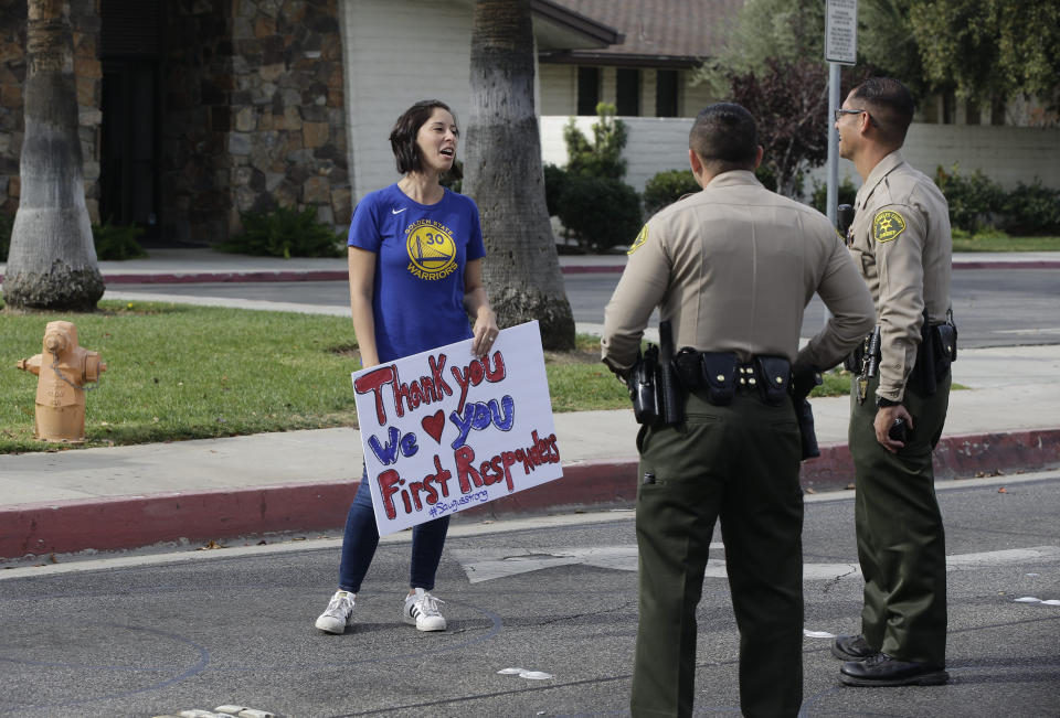 Santa Clarita resident Veronica Candy thanks Los Angeles Sheriff deputies outside the Saugus High School in Santa Clarita, Calif., Friday, Nov. 15, 2019. A homicide official says that investigators did not find a diary, manifesto or note belonging to the boy who killed two people outside his Southern California high school on his 16th birthday. Officials held a press conference Friday outside of the police station Santa Clarita. No motive or rationale has been established yet in the Thursday morning shooting at Saugus High School in the Los Angeles suburb of Santa Clarita. (AP Photo/Damian Dovarganes)