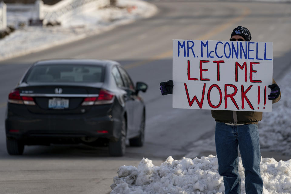 Furloughed EPA worker Jeff Herrema holds a sign outside the offices of U.S. Senator Mitch McConnell, in Park Hills, Ky., Tuesday, Jan 22, 2019. (AP Photo/Bryan Woolston)