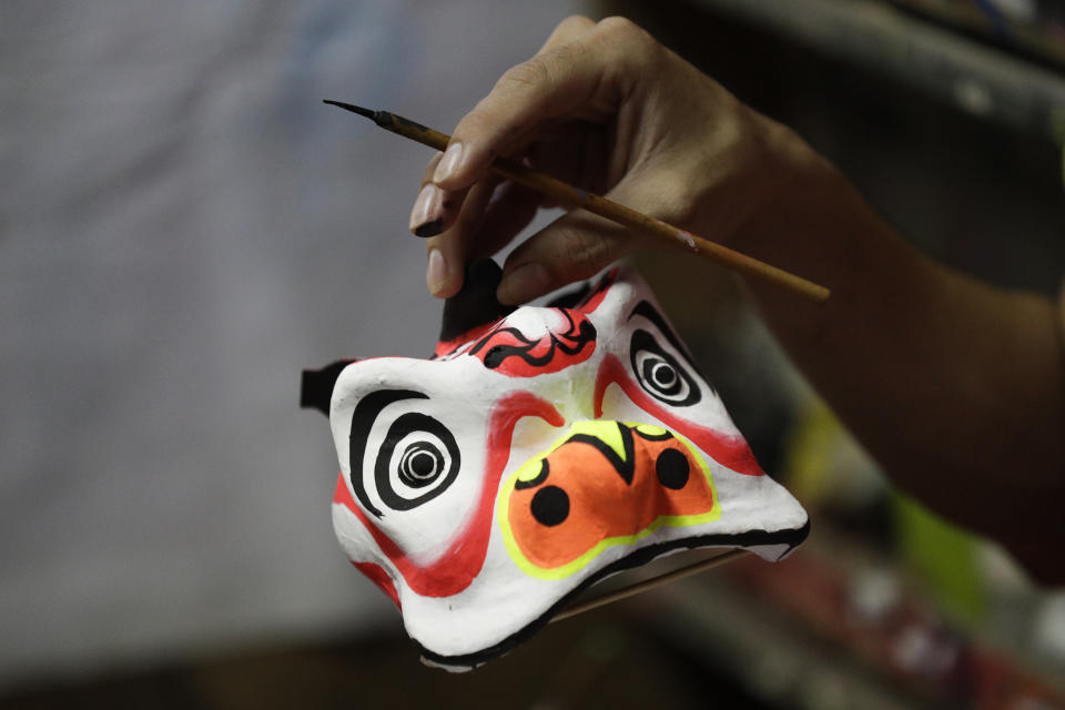 A miniature lion head is carried as it is prepared to be painted as a dragon and lion dance group seek other ways to earn a living at a creekside slum at Manila's Chinatown, Binondo Philippines on Feb. 3, 2021. The Dragon and Lion dancers won't be performing this year after the Manila city government banned the dragon dance, street parties, stage shows or any other similar activities during celebrations for Chinese New Year due to COVID-19 restrictions leaving several businesses without income as the country grapples to start vaccination this month. (AP Photo/Aaron Favila)