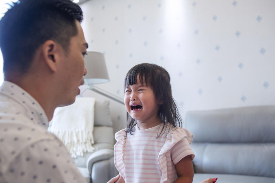 Adult comforting a crying child indoors