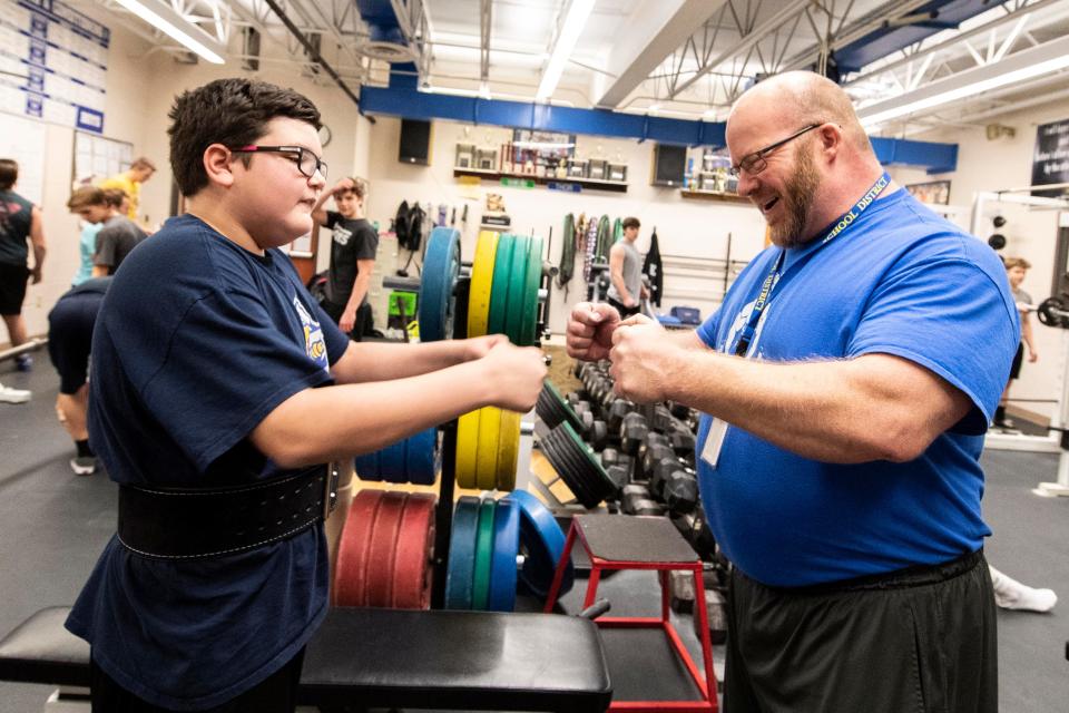 Kennard-Dale powerlifting head coach Niko Hulslander, right, fist bumps with then-sophomore Brian Rasmuson in 2018. Rasmuson has autism but still competed for the powerlifting team.