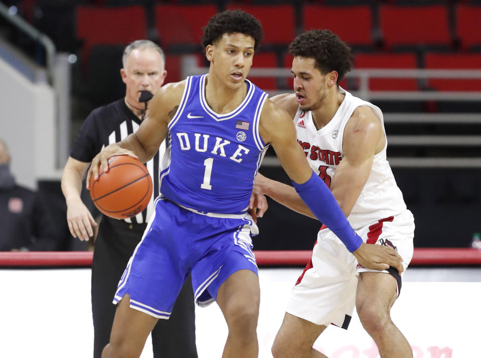 Duke's Jalen Johnson (1) looks for space as N.C. State's Jericole Hellems (4) defends during the first half of an NCAA college basketball game against North Carolina State in Raleigh, N.C., Saturday, Feb. 13, 2021. (Ethan Hyman/The News & Observer via AP)