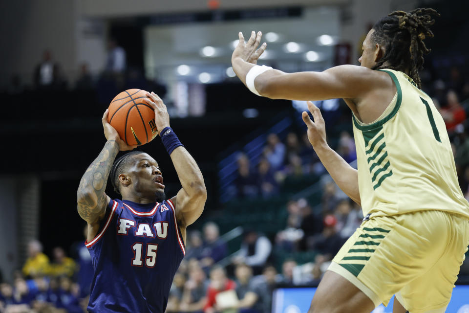 Florida Atlantic guard Alijah Martin (15) drives to the basket against Charlotte center Dishon Jackson, right, during an NCAA college basketball game in Charlotte, N.C., Saturday, Jan. 6, 2024. (AP Photo/Nell Redmond)