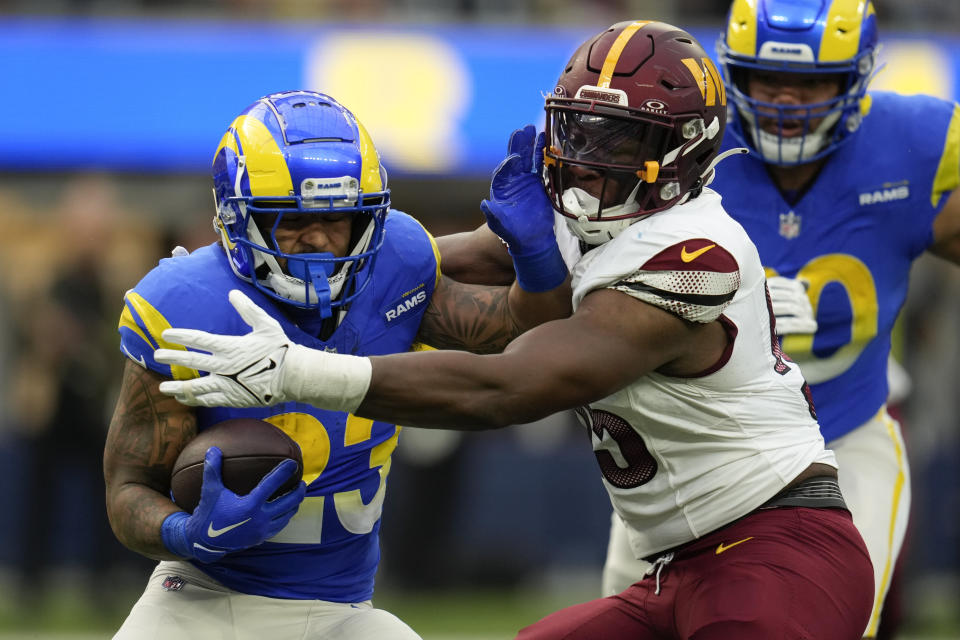 Los Angeles Rams running back Kyren Williams (23) is tackled by Washington Commanders defensive end KJ Henry (55) during the first half of an NFL football game Sunday, Dec. 17, 2023, in Inglewood, Calif. (AP Photo/Marcio Jose Sanchez)