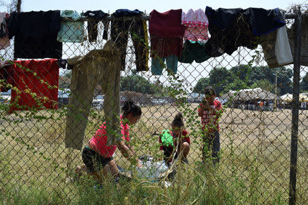 Migrants from Central America wash their clothes at a improvised shelter while waiting for their humanitarian visas to cross the country on their way to the United States, in Mapastepec, in Chiapas state, Mexico April 3, 2019. REUTERS/Jose Torres