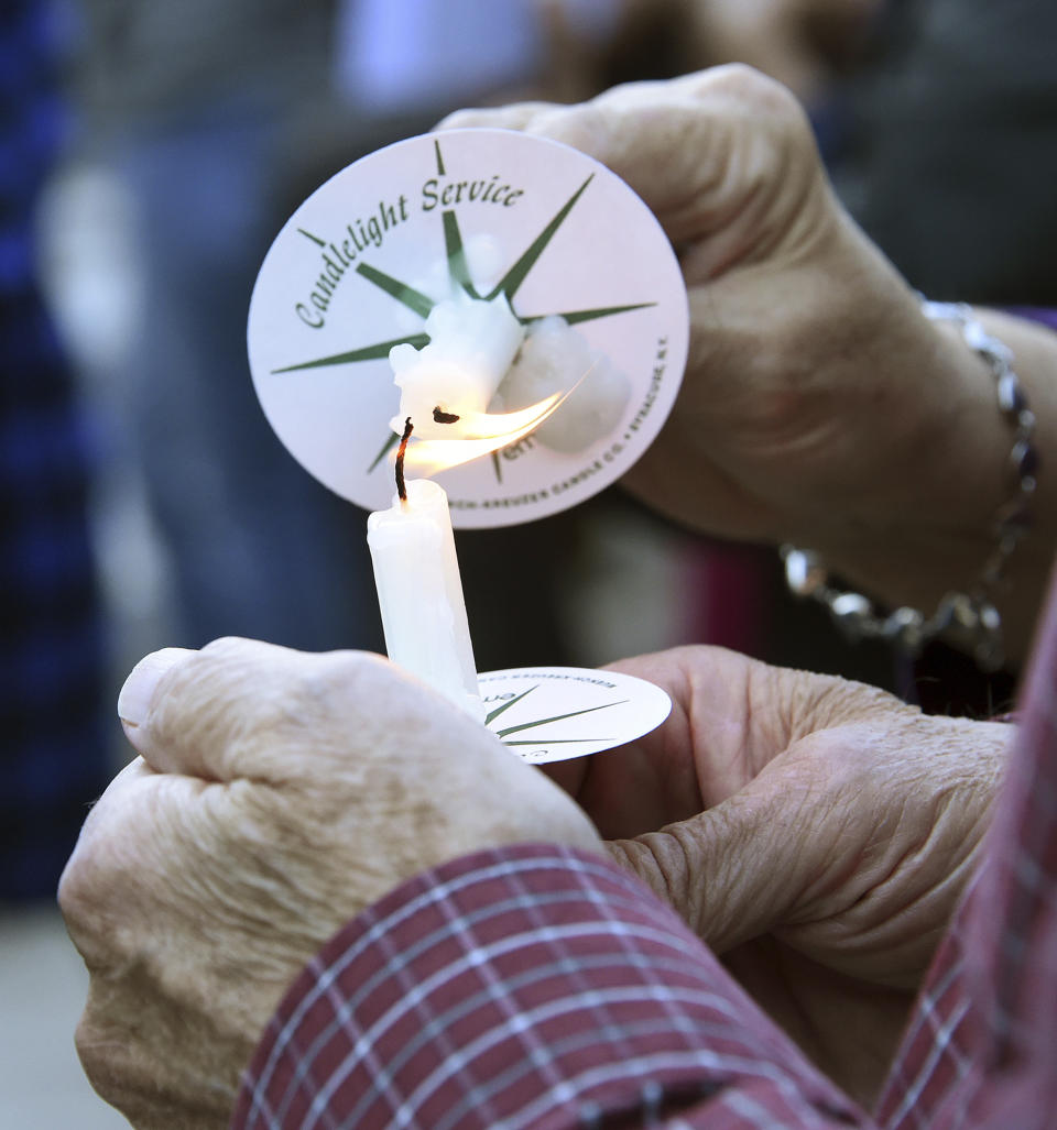 People hold candles during a vigil held for Kamille "Cupcake" McKinney in Linn Park in front of Birmingham City Hall in Birmingham, Ala. Wednesday, Oct. 23, 2019. Police say they will charge two people with kidnapping and capital murder in the death of the 3-year-old Alabama girl whose body was found amid trash 10 days after being kidnapped outside a birthday party. (Joe Songer/AL.com. via AP)