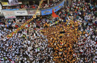 <p>Indian devotees show a black flag standing on the top of a human pyramid before breaking dahi handi, a pot filled with curd, during a protest against the Indian court order of imposing height restrictions on human pyramids formed during the festivities and banning youngsters below 18 years from participating, in Mumbai, India, Aug. 25, 2016. The holiday marks the birth of Hindu God Krishna. (Photo: Rafiq Maqbool/AP) </p>