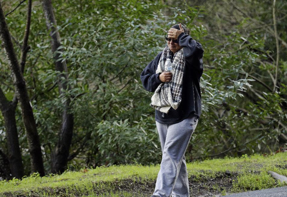 The mother of a missing 18-year-old woman places her hand to her head after viewing the scene where her daughter's car careened off the road Monday, Jan. 23, 2017, on Niles Canyon Road near Fremont, Calif. The unidentified woman's car plunged into rushing waters after colliding with another vehicle on Saturday and is suspected as being in the submerged vehicle. (AP Photo/Ben Margot)