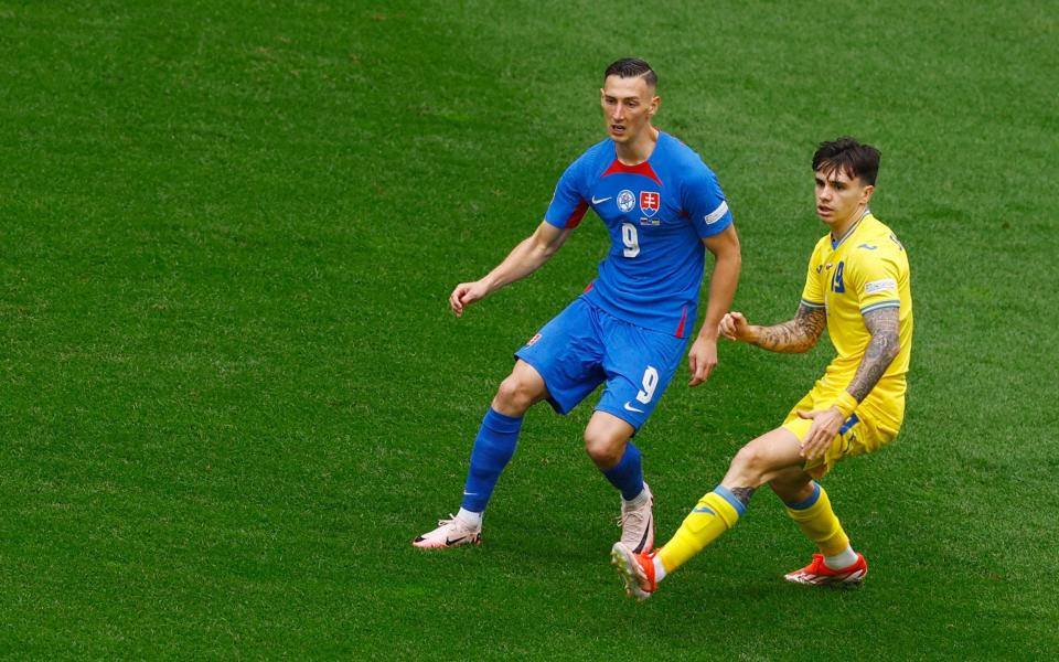 Slovakia's Robert Bozenik is shadowed by Mykola Shaparenko.