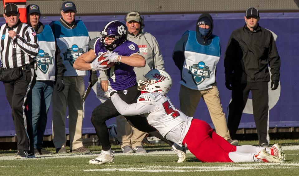 Holy Cross running back Peter Oliver drags a Sacred Heart University player down the sideline.