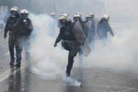 A Greek riot police kicks a tear gas grenade during clashes in Athens, Sunday, Jan. 20, 2019. Greece's Parliament is to vote this coming week on whether to ratify the agreement that will rename its northern neighbor North Macedonia. Macedonia has already ratified the deal, which, polls show, is opposed by a majority of Greeks. (AP Photo/Thanassis Stavrakis)