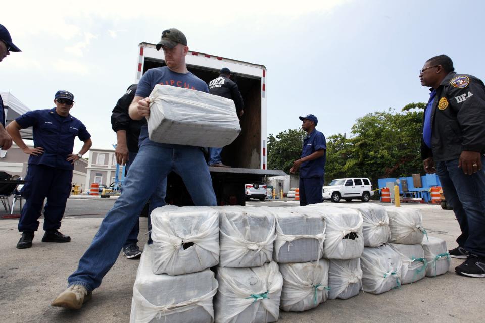 U.S. Coast Guards display part of the 1280 kg (2822 pounds) of cocaine, which is worth an estimated $37 million, seized in a routine patrol during a media presentation in San Juan, May 6, 2014. The Coast Guard recovered the drugs on April 29 during an at-sea interdiction south of Puerto Rico and also arrested two traffickers from the Dominican Republic. REUTERS/Ana Martinez (PUERTO RICO - Tags: CRIME LAW DRUGS SOCIETY)