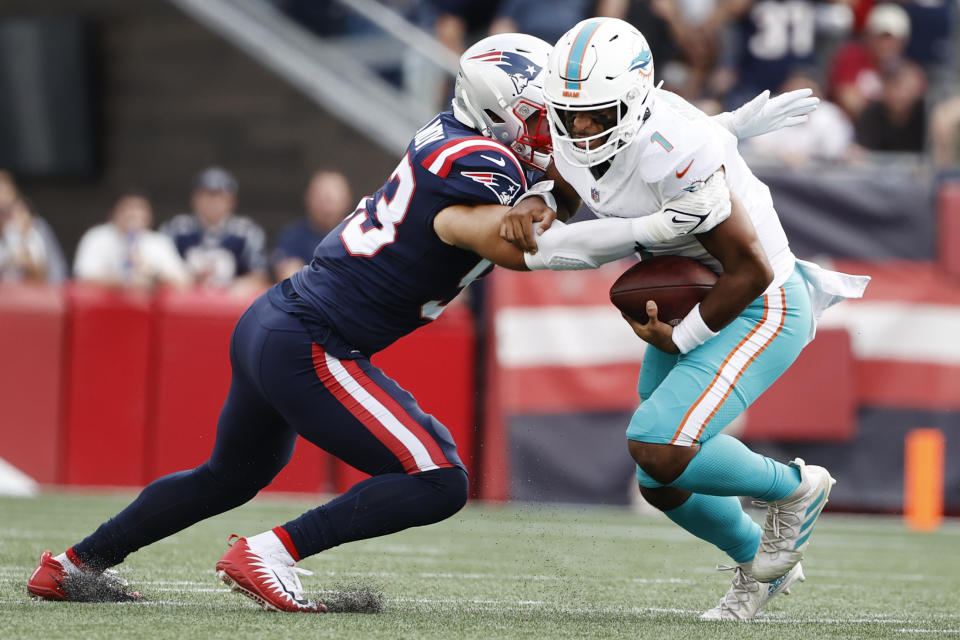 New England Patriots middle linebacker Kyle Van Noy, left, takes down Miami Dolphins quarterback Tua Tagovailoa, right, during the first half of an NFL football game, Sunday, Sept. 12, 2021, in Foxborough, Mass. (AP Photo/Winslow Townson)