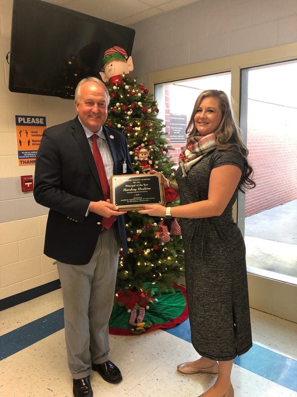 Superintendent Will Hoffman awards Mars Hill Elementary School Principal Marshay Huskins with the 2021-22 Principal of the Year plaque.