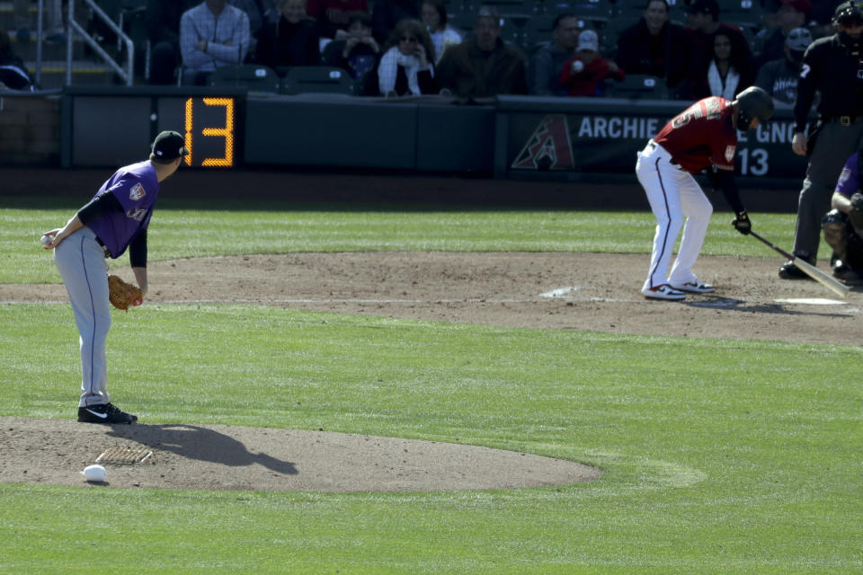 A pitch clock counts down as Colorado Rockies pitcher Chi Ci Gonzalez prepares the throw to Arizona Diamondbacks' Ildemaro Vargas during a spring baseball game in Scottsdale, Ariz., Saturday, Feb. 23, 2019. (AP Photo/Chris Carlson)