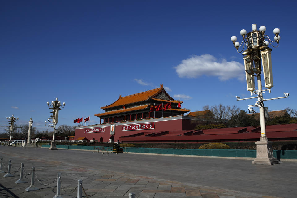 In this Sunday, Feb. 16, 2020, photo, a masked paramilitary policeman stands guard alone at a deserted Tiananmen Gate following the coronavirus outbreak, in Beijing. China said Monday it may postpone its annual congress in March, its biggest political meeting of the year, as the military dispatched hundreds more medical workers and extra supplies to the city hit hardest by a 2-month-old virus outbreak. (AP Photo/Andy Wong)