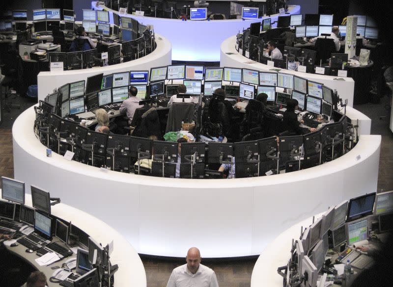 Traders are pictured at their desks at the Frankfurt stock exchange