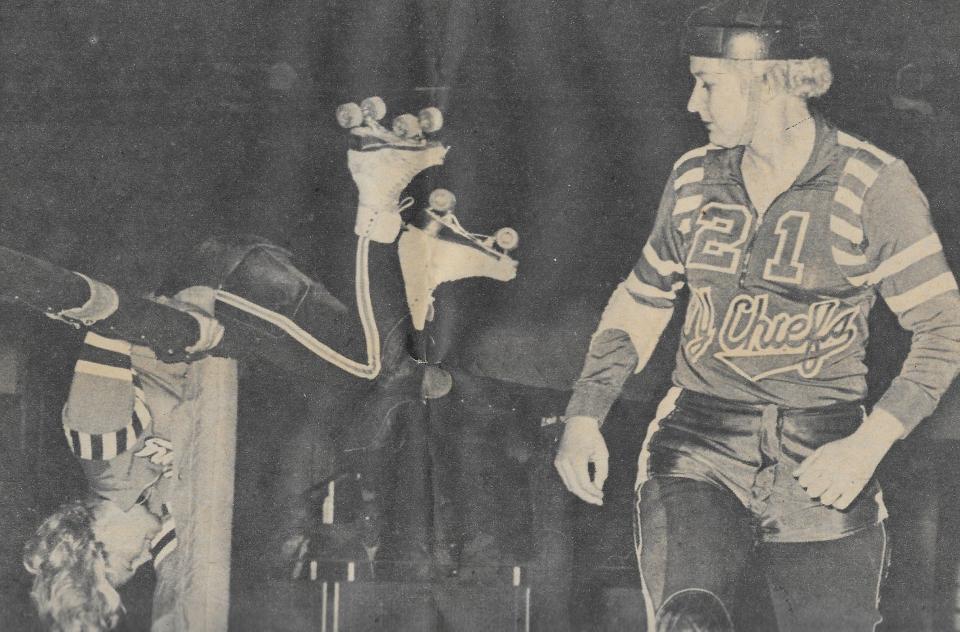 A dazed opponent crashes over the railing as New York Chiefs captain skates away in 1966. This image is from a clipping in the Beacon Journal archives.