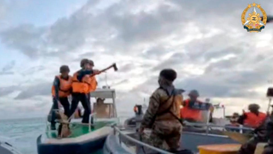 菲律賓武裝部隊公布照片，2024年6月17日中國海警人員駕汽艇阻擋菲國補給船前往仁愛暗沙，還持刀斧指向菲軍水手。美聯社